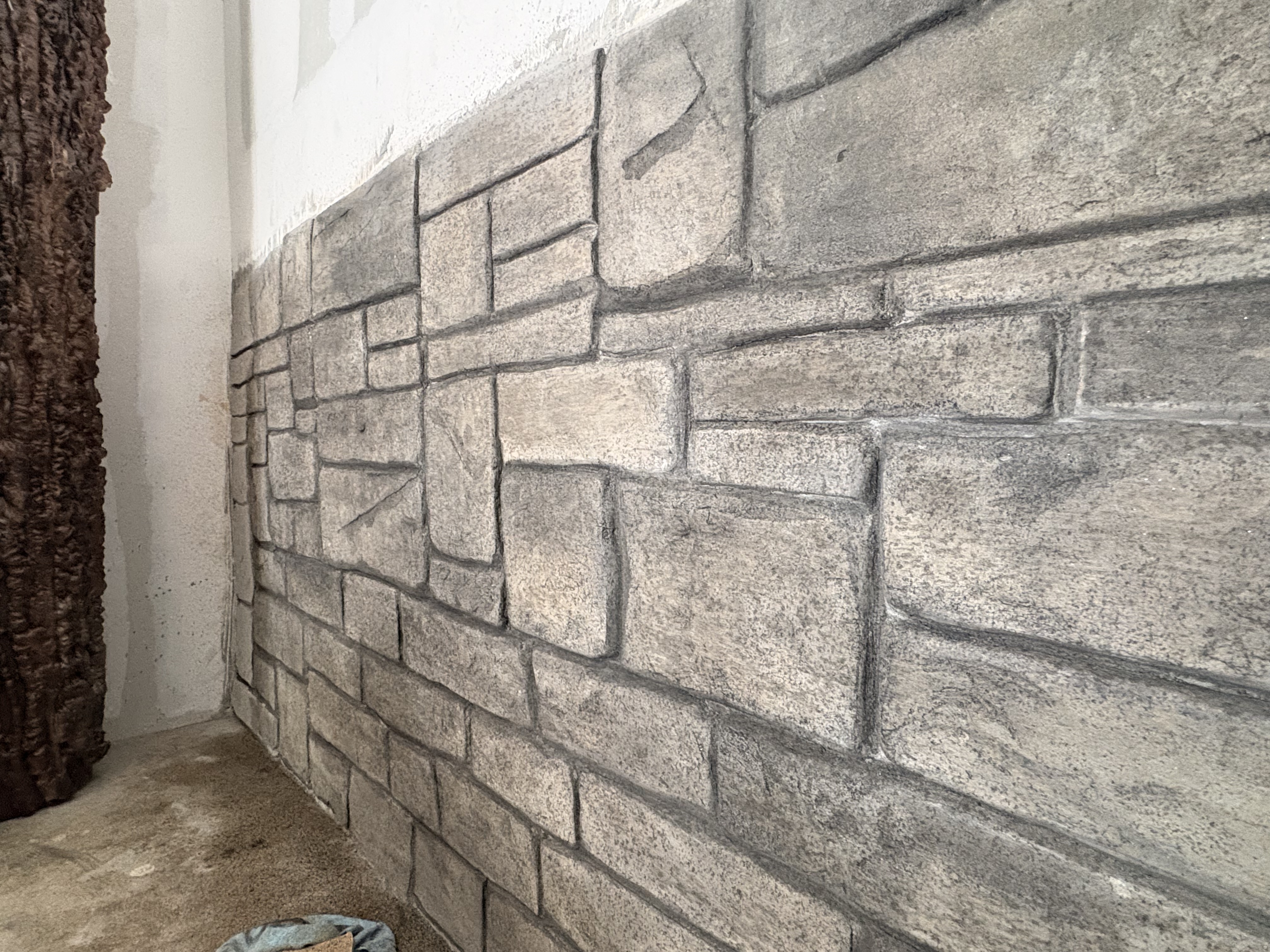 Close-up detail of a hand-sculpted brick and stone textured wall